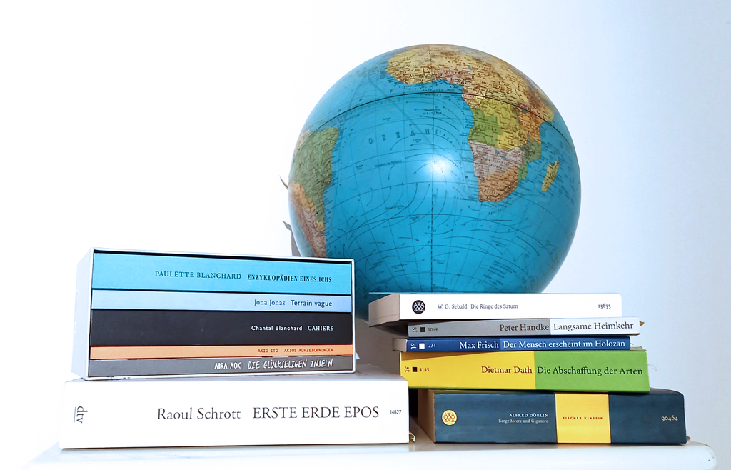 A globe next to two stacks of books on Anthropocene-related topics