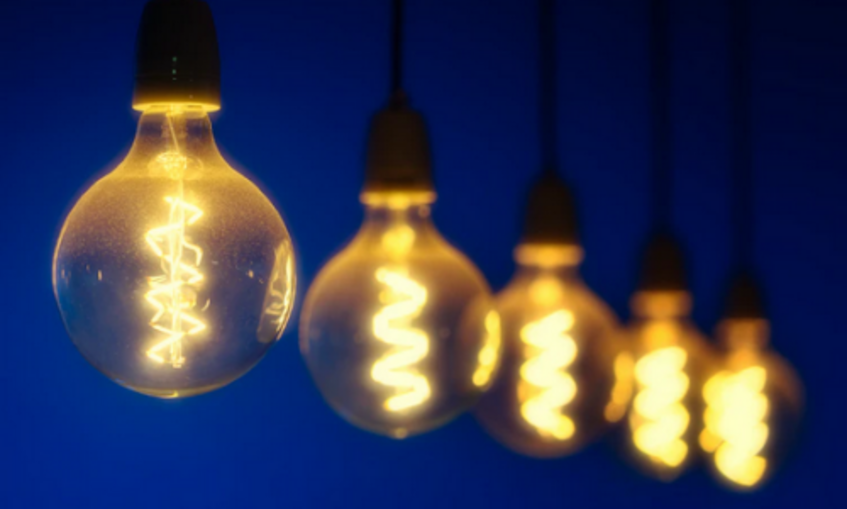 Five lightbulbs in a row, emitting a soft yellow glow against a dark blue background