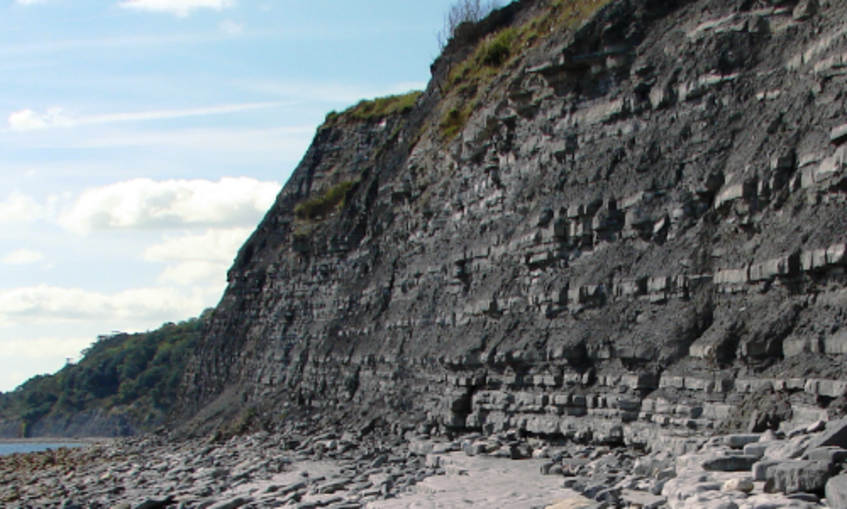 Cliff of grey rock with geological layers (strata) clearly visible