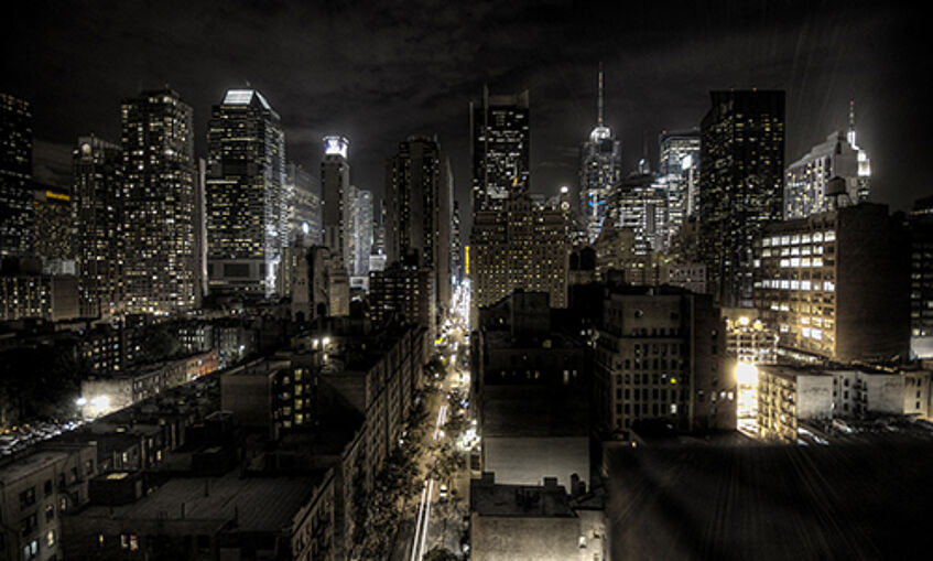 New York city at night, lit-up skyscrapers against a black sky