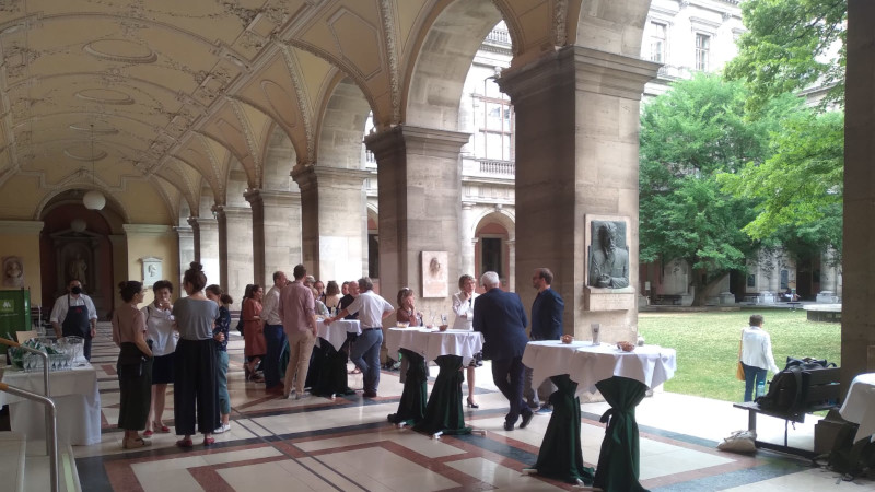 Photo taken at the official launch of the Infranorth project, showing a group of attendees gathered in the arcaded courtyard of the University of Vienna