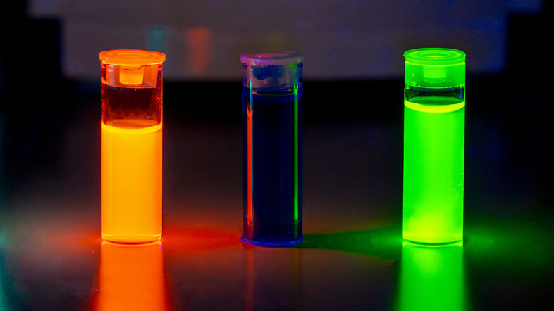 Test tubes containing flourescent molecules in orange and green